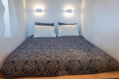 - un lit dans une petite chambre avec 2 oreillers dans l'établissement An Attractive Paris Flat near Jardin du Luxembourg , Saint-Germain, à Paris
