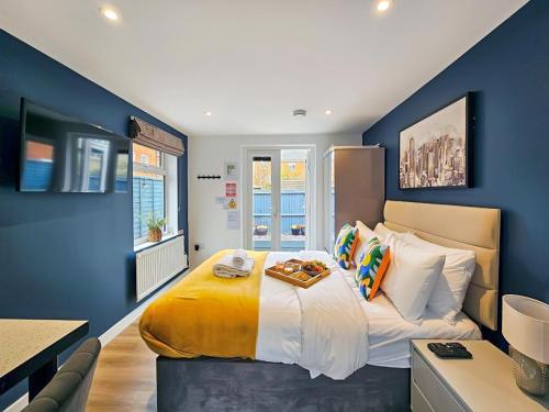 a bedroom with a large bed with blue walls at Blue Garden Retreat by Fortuna Property Portfolio in Cheltenham