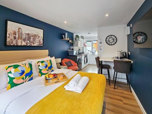 a bedroom with a large bed with a yellow bench at Blue Garden Retreat by Fortuna Property Portfolio in Cheltenham