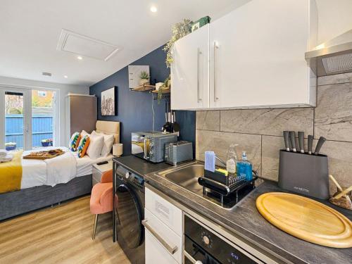 a kitchen with a sink and a bed in a room at Blue Garden Retreat by Fortuna Property Portfolio in Cheltenham