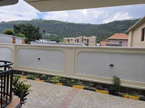 a white fence with a view of a mountain at Jikoni Hotel in Gisenyi
