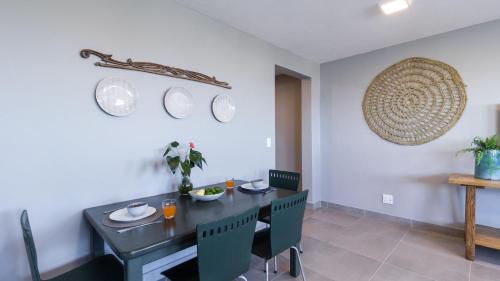 a dining room with a black table and chairs at Budapest Boutique Hotel in Edgemead