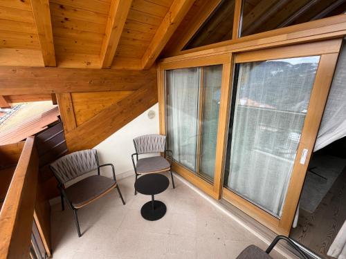 an attic room with two chairs and windows at Folgaria Top Rent in Folgaria