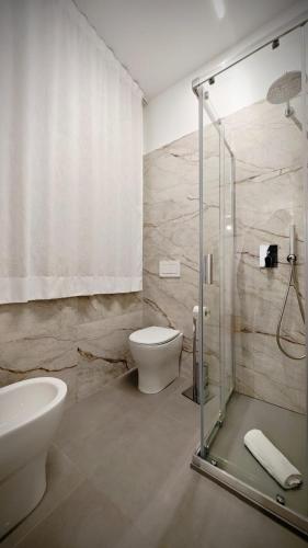 a bathroom with a toilet and a glass shower at Giuliani Rooms in Ancona