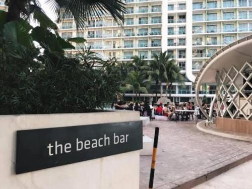 a sign for the beach bar in front of a building at Azure Urban Resort Staycation in Manila