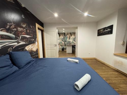 a bedroom with a blue bed with two towels on it at Le Garage de Cuba in Épinal
