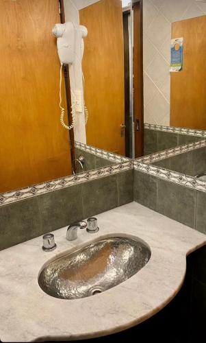 a bathroom with a sink and a mirror at Hotel Samay Huasi in Villa General Belgrano