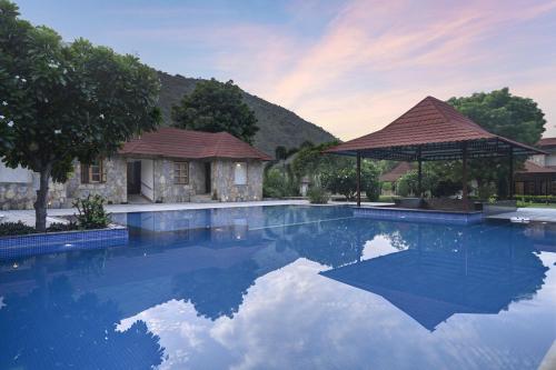 a large swimming pool with a gazebo at Anandam - A Luxury Resort in Udaipur in Udaipur