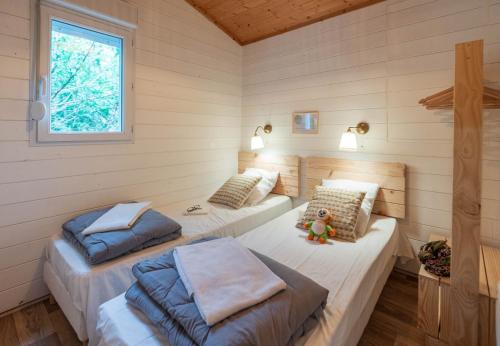- une chambre avec 3 lits dans une cabine dans l'établissement Sunêlia Camping la Presqu'île, à Prunières