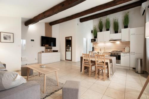 une cuisine et un salon avec une table et des chaises dans l'établissement Nézignan l évêque 3km de Pezénas Suit'Appart 70m2, à Nézignan-lʼÉvêque
