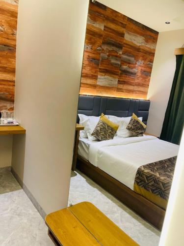 a bedroom with a bed with a wooden headboard at HOTEL DOUBLE CROWN Mumbai AIRPORT T2 in Mumbai