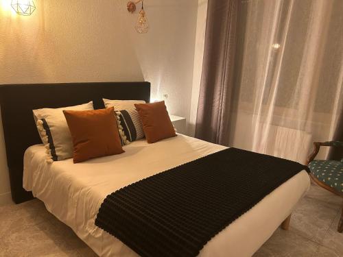 a bedroom with a bed with brown and black pillows at Villa Antibes Chez Celine in Étaples
