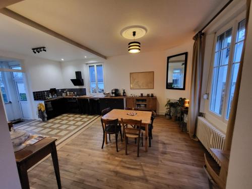 une cuisine et une salle à manger avec une table et des chaises dans l'établissement Maison Plestin proche plage et GR 34 avec Jardin, à Plestin-les-Grèves