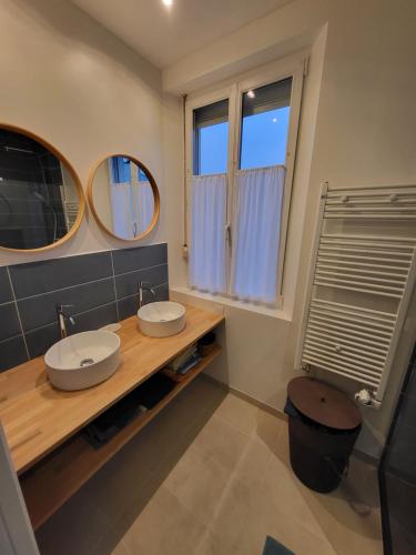 a bathroom with two sinks and two mirrors at Maison Plestin proche plage et GR 34 avec Jardin in Plestin-les-Grèves