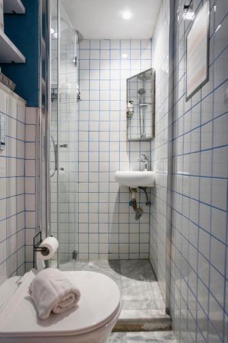 a bathroom with a toilet and a sink and a shower at Mandera's Boutique Suites & Dorms in Valletta