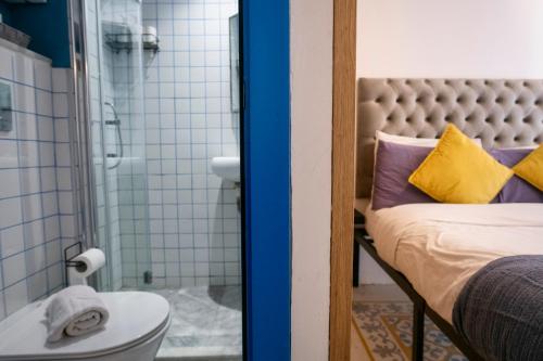 a bathroom with a bed and a shower and a toilet at Mandera's Boutique Suites & Dorms in Valletta