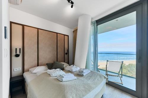 een slaapkamer met een bed met uitzicht op de oceaan bij Wave Sea View Private Apartment - A864 in Międzyzdroje