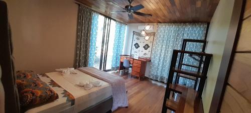 a bedroom with a bed and a window and a desk at Corcovado Eco Lodge Villas-Houses-Tents-Mountain-Ocean Views in Puerto Jiménez
