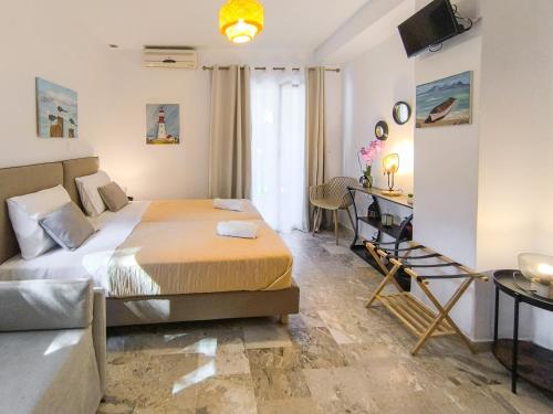 a bedroom with a bed and a desk and a couch at 3 Goddesses' studios in Koukounaries