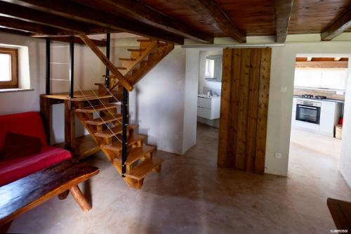 - un salon avec un escalier en colimaçon dans une maison dans l'établissement Authentique Casellu en pierre à Porticcio avec vue sur la mer, à Porticcio