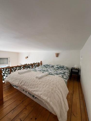 Ce lit se trouve dans une chambre dotée de parquet. dans l'établissement Appartement vue sur la Basilique - Boulogne-sur-mer, à Boulogne-sur-Mer