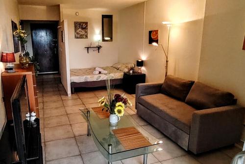 un salon avec un canapé et une table dans l'établissement Studio cosy Balcon Aperçu mer, à Antibes