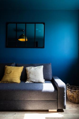 une chambre bleue avec un canapé en face d'un mur bleu dans l'établissement Beau T2 avec vue en centre TOULOUSE COMPANS, à Toulouse