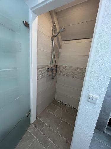 a bathroom with a shower with a tile floor at Hus Sylroede 37 in Lemmer