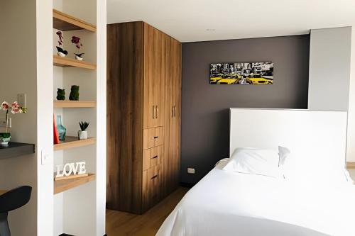 a bedroom with a white bed and a black wall at Domus Suites Chia in Chía