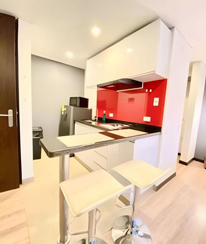 a kitchen with red cabinets and a table and chairs at Domus Suites Chia in Chía