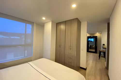 a bedroom with a bed and a large window at Domus Suites Chia in Chía