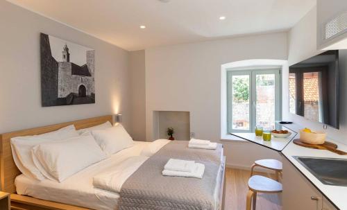 a bedroom with a bed and a kitchen with a counter at Old Town Apartments u nikse in Dubrovnik