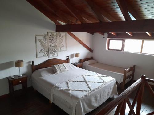a bedroom with a bed and a table and two windows at Curahue Apart Hotel in Tandil