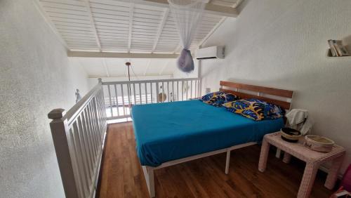 una camera da letto con un letto con un piumone blu di Chez Michèle a Saint-François