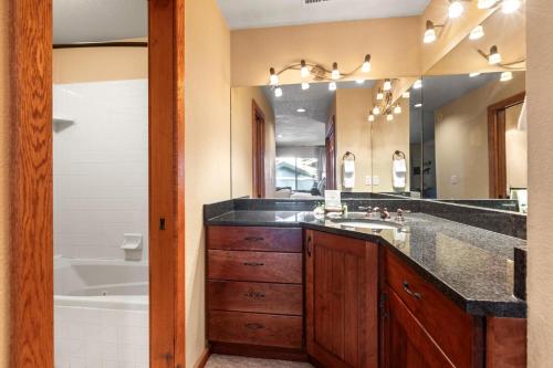 a bathroom with a sink and a tub and a mirror at KBM Resorts Upgraded Easy walk to Main St Close to Deer Valley hot tub gas fireplace BCC-1101 in Park City