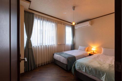 a hotel room with two beds and a window at THE HOTEL of TOKYO akasaka in Tokyo