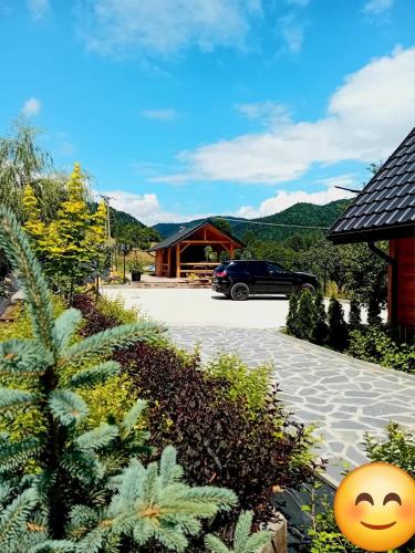 a house with a car parked in a driveway at Apartamenty Na Brzegu Szczawnica in Szczawnica