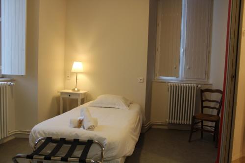 a small room with a bed and a chair at Le grand couvent de Gramat in Gramat