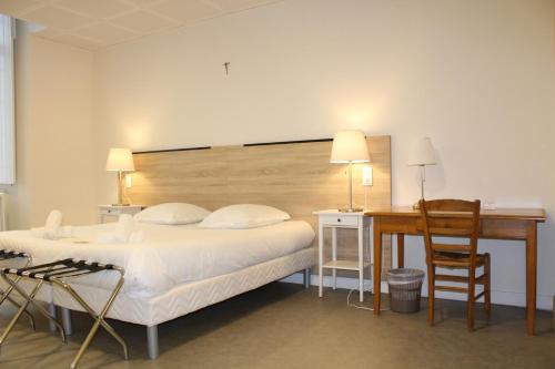 a bedroom with a bed and a desk and a table at Le grand couvent de Gramat in Gramat
