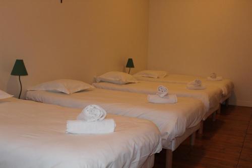 a room with three beds with towels on them at Le grand couvent de Gramat in Gramat