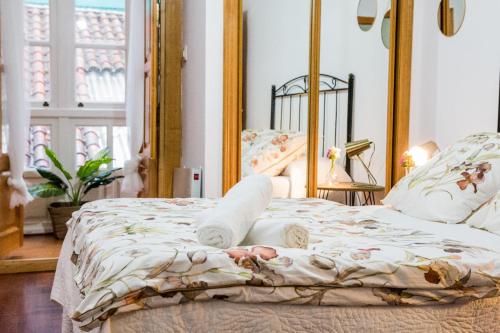 a bedroom with a bed with a mirror at Pensión 5 Caminos in Santiago de Compostela