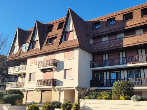 un immeuble avec un toit brun dans l'établissement 2 Pièces Résidence EVENTAIL et MER, à Cabourg