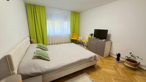 a bedroom with a bed with a green curtain at Ego Residence Alba Iulia in Alba Iulia