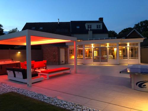 a patio with a pavilion with red benches and tables at B&B Carpe Diem in Westerlo