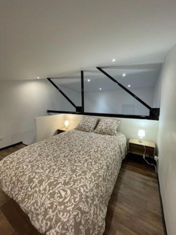 une chambre avec un grand lit dans une pièce dans l'établissement Studio mezzanine centre-ville, à Elbeuf