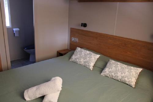 une chambre avec un lit vert avec deux oreillers dans l'établissement Mobilhome Gamme résidentielle, au Muy