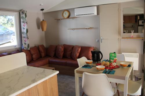 un salon avec un canapé et une table dans l'établissement Mobilhome Gamme résidentielle, au Muy