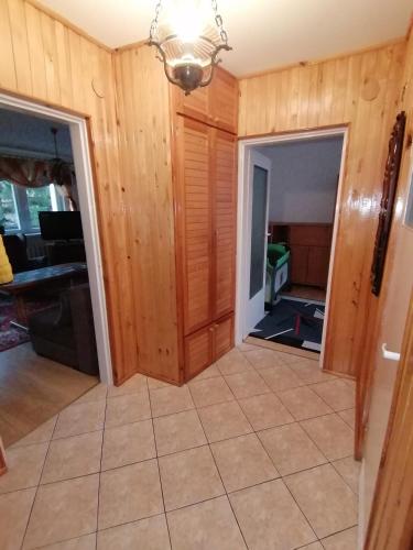 a living room with wooden walls and a tile floor at Nocleg przy Ratuszu in Pieniężno