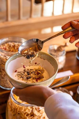 a person is serving a bowl of food with a spoon at Rossalm in Brixen