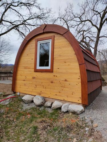 a large wooden building with a window in a yard at Camping du Moulin de Thoard in Thoard